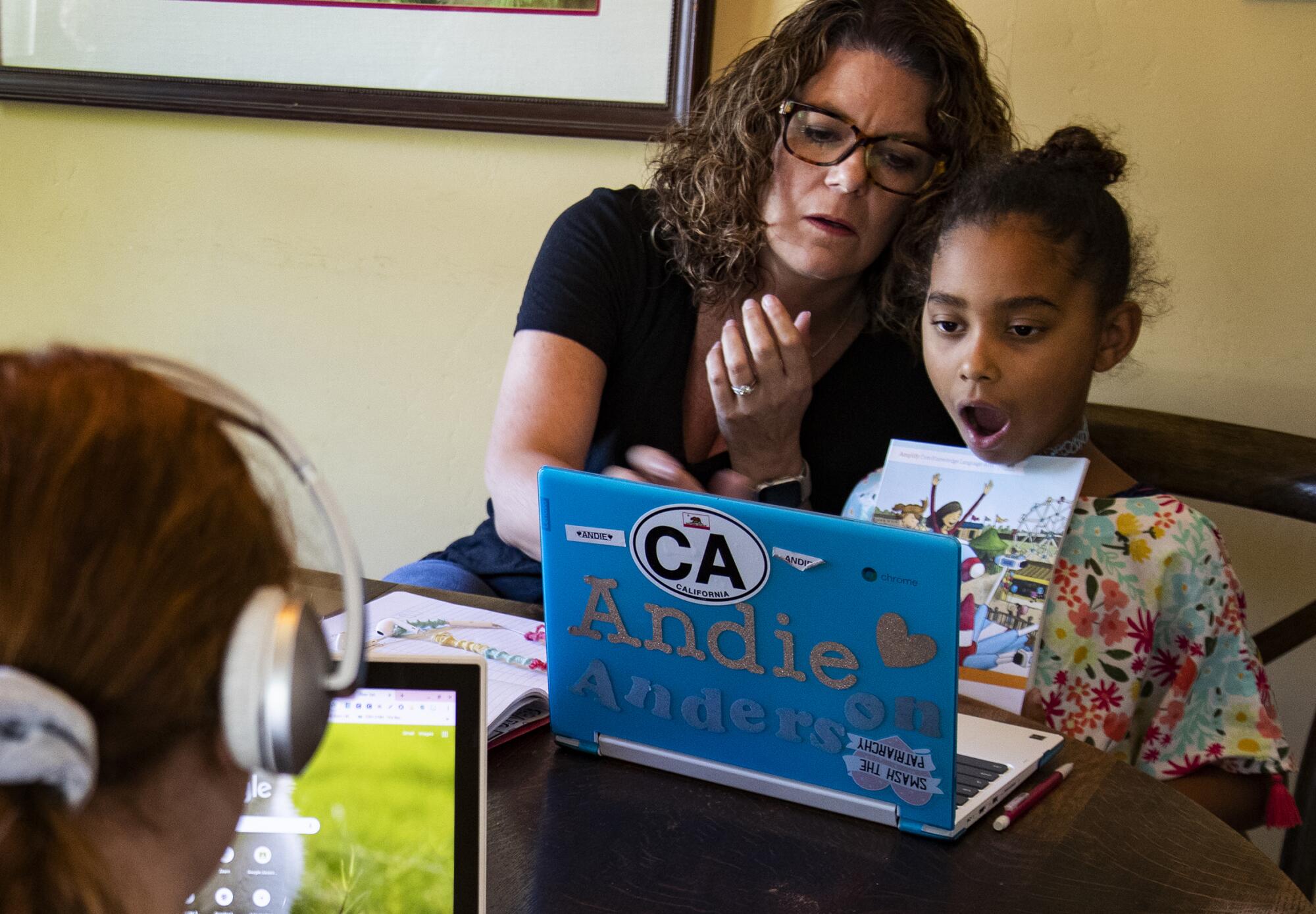 Former third-grade teacher Kristen Bristow helps her daughter Andie, 6, with homework.