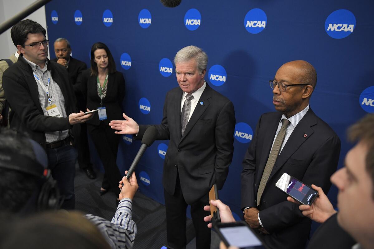 NCAA President Mark Emmert, center, speaks to reporters at the NCAA convention on Thursday in Anaheim.