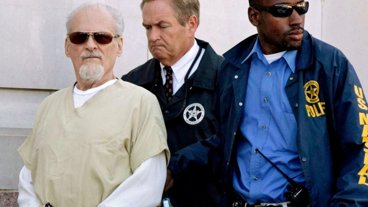 Tony Alamo, left, is escorted to a waiting police car outside the federal courthouse in Texarkana, Ark., in 2009.