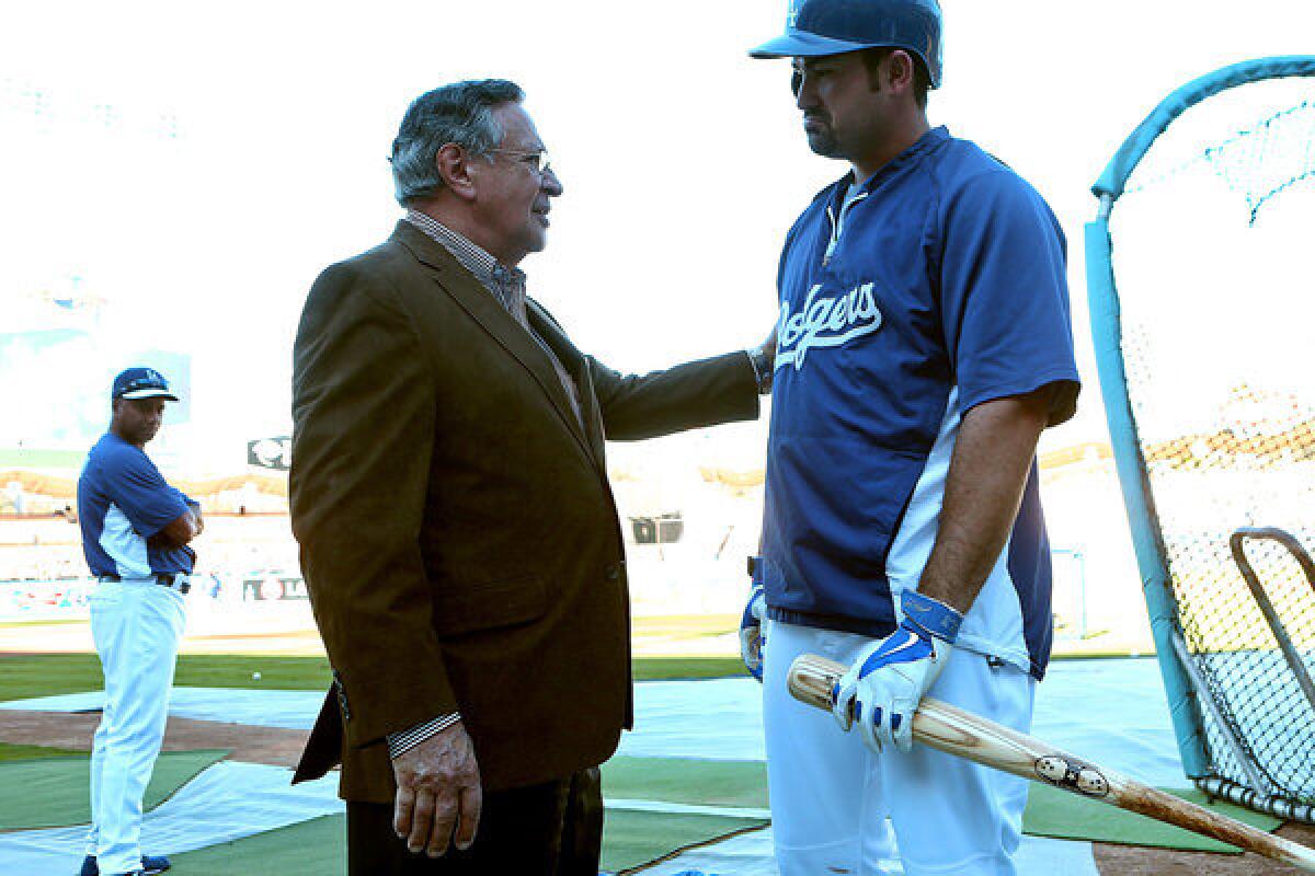 Announcer Jaime Jarrin chats with Dodgers first baseman Adrian Gonzalez on the field before a playoff game at Dodger Stadium in 2013.