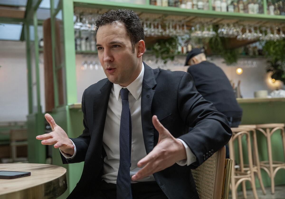 Actor Ben Savage gestures while seated at a cafe in West Hollywood