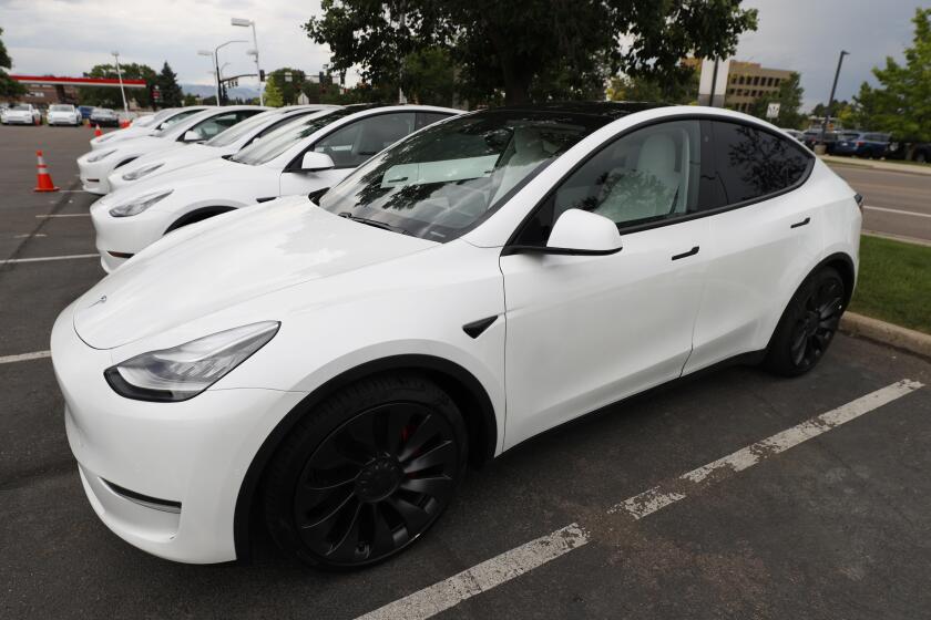In this Sunday, June 28, 2020, photograph, a long line of unsold 2020 Model Y sports-utility vehicles sits at a Tesla dealership in Littleton, Colo. (AP Photo/David Zalubowski)