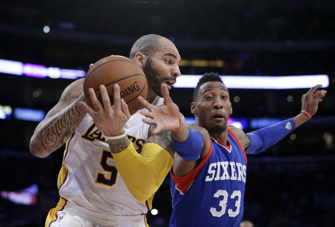 Lakers forward Carlos Boozer gets a rebound against 76ers forward Robert Covington during the first half.