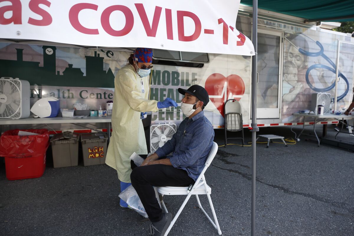 A nurse administers a coronavirus test on a patient