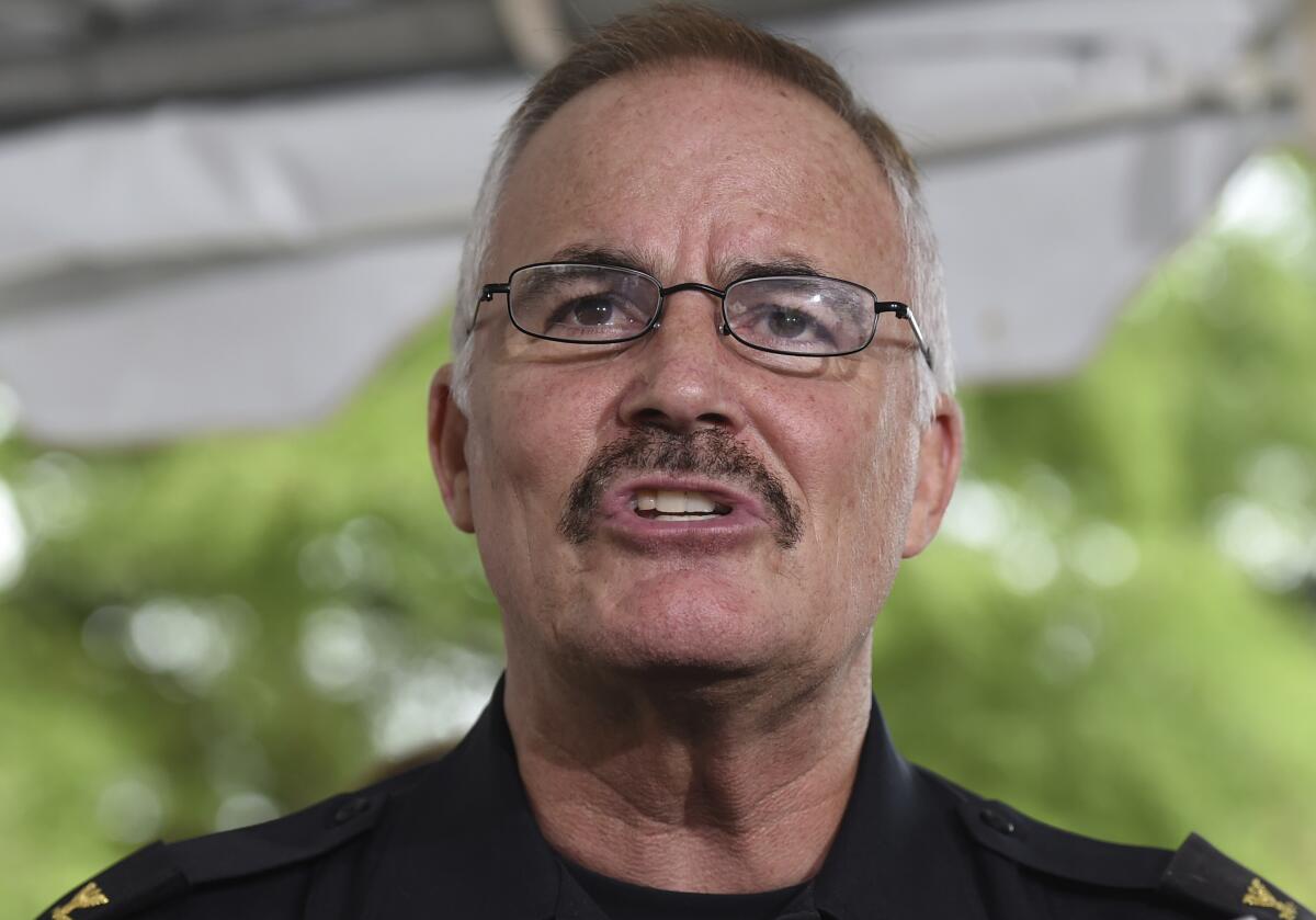 A man with a mustache and glasses speaks