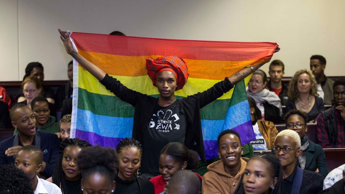 An activist holds up a flag in the courtroom to celebrate the Botswana High Court's rejection of sections of the penal code punishing same-sex relations. The court ruled in Gaborone on Tuesday.