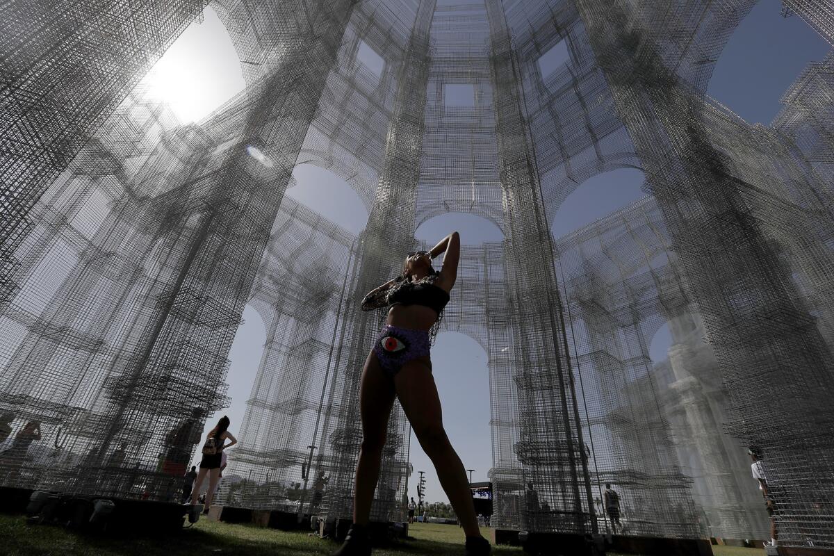 Sophia Roth, of Reno, Nev., takes in the sun inside an art piece called "Etherea" by Eduardo Tresoldi during the Coachella Valley Music and Arts Festival in Indio.