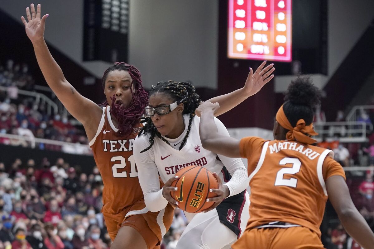 Stanford forward Francesca Belibi, middle, drives to the basket between Texas forward Aaliyah Moore (21) and guard Aliyah Matharu (2) during the first half of an NCAA college basketball game in Stanford, Calif., Sunday, Nov. 14, 2021. (AP Photo/Jeff Chiu)