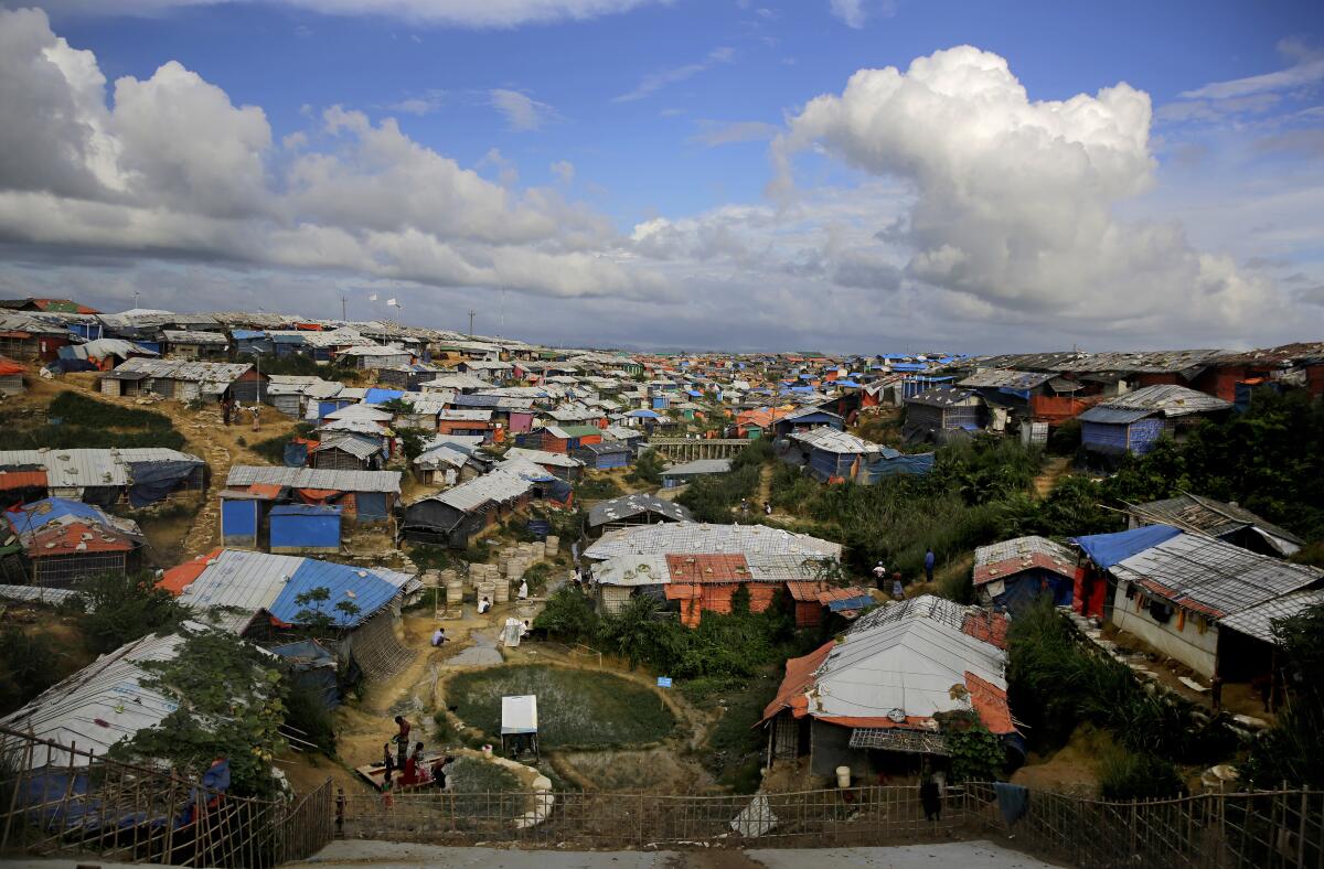 Rohingya refugees bathe at a hand water pump at a refugee camp in Bangladesh in 2018.