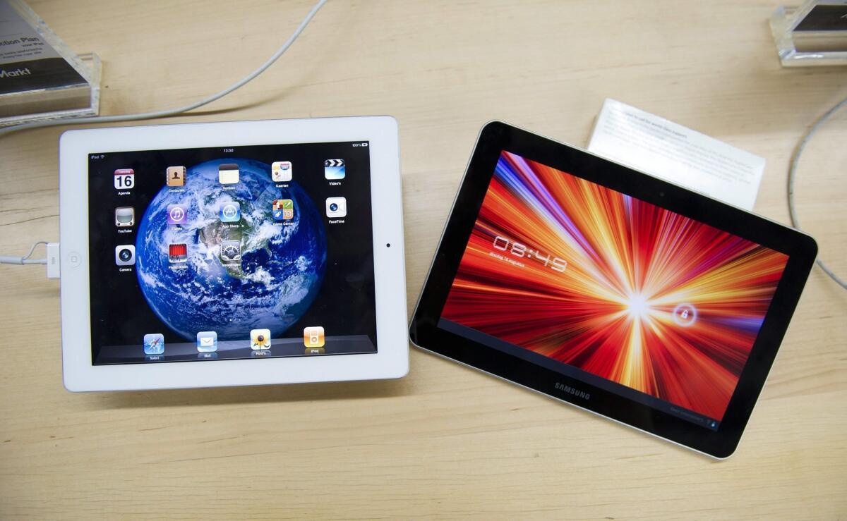 An Apple iPad, left, and a Samsung Galaxy Tab 10.1 at a store in The Hague, the Netherlands. Tablet owners say they know more about what's in the news than their tablet-less peers, according to a survey.