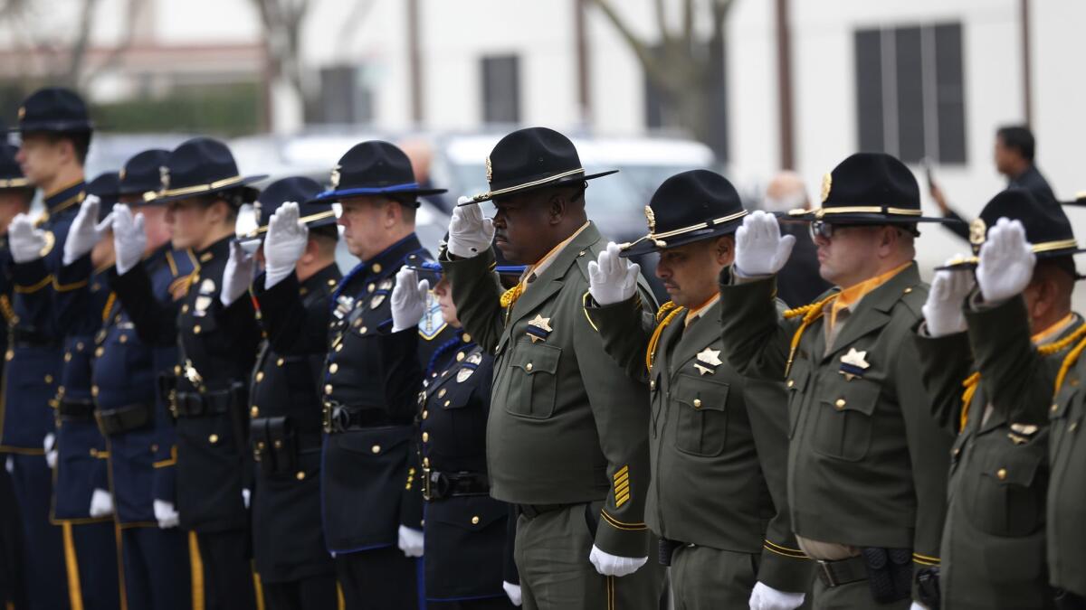 Police officers salute family members of slain Newman Police Cpl. Ronil Singh.