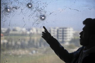 Bullet holes in a window following violence between Syrian security forces and gunmen loyal to former President Bashar Assad