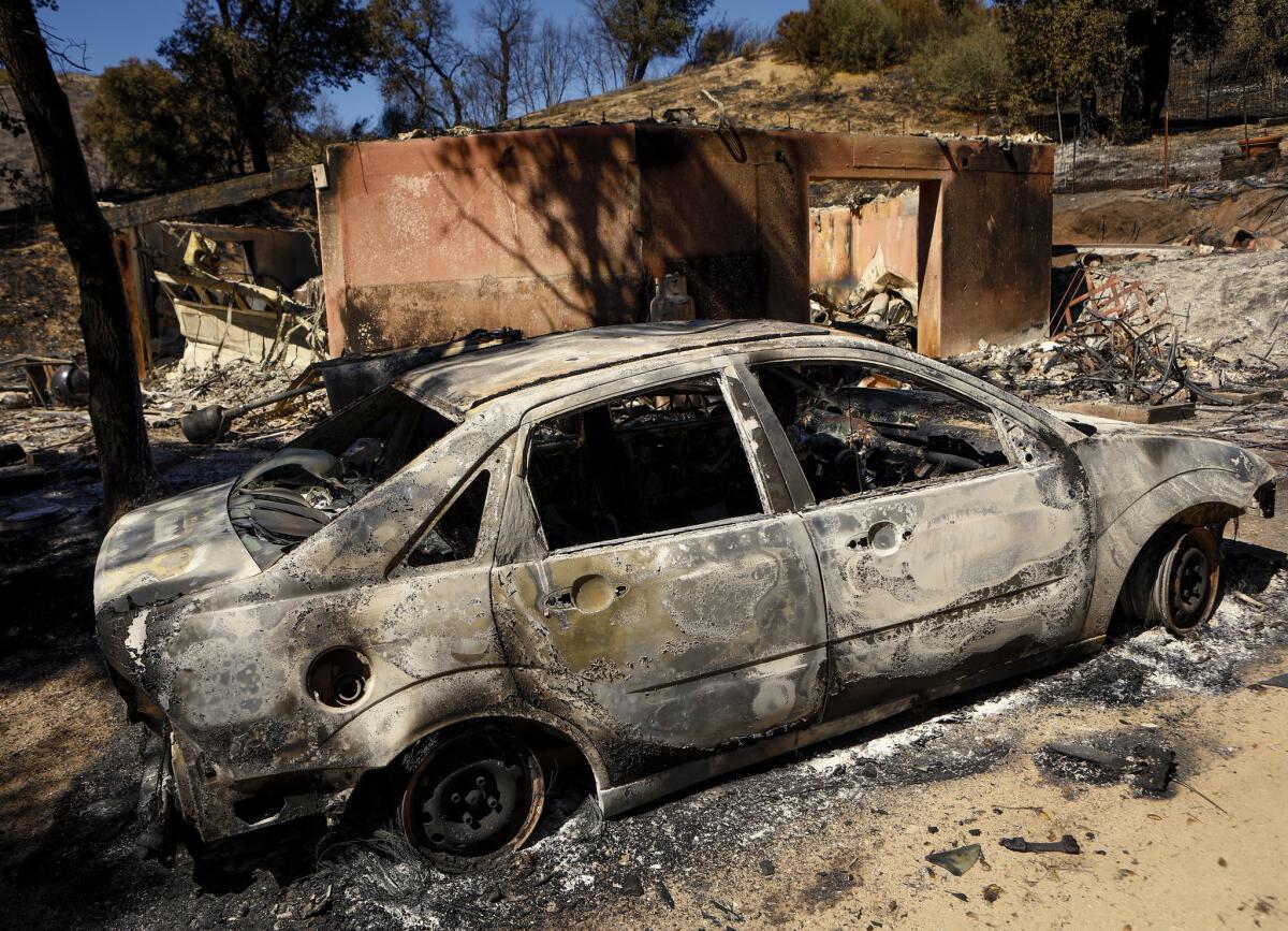 A burned-out car sits next to a destroyed home after a wildfire in Santa Margarita on Wednesday, June 28, 2017. (Joe Johnston / AP)