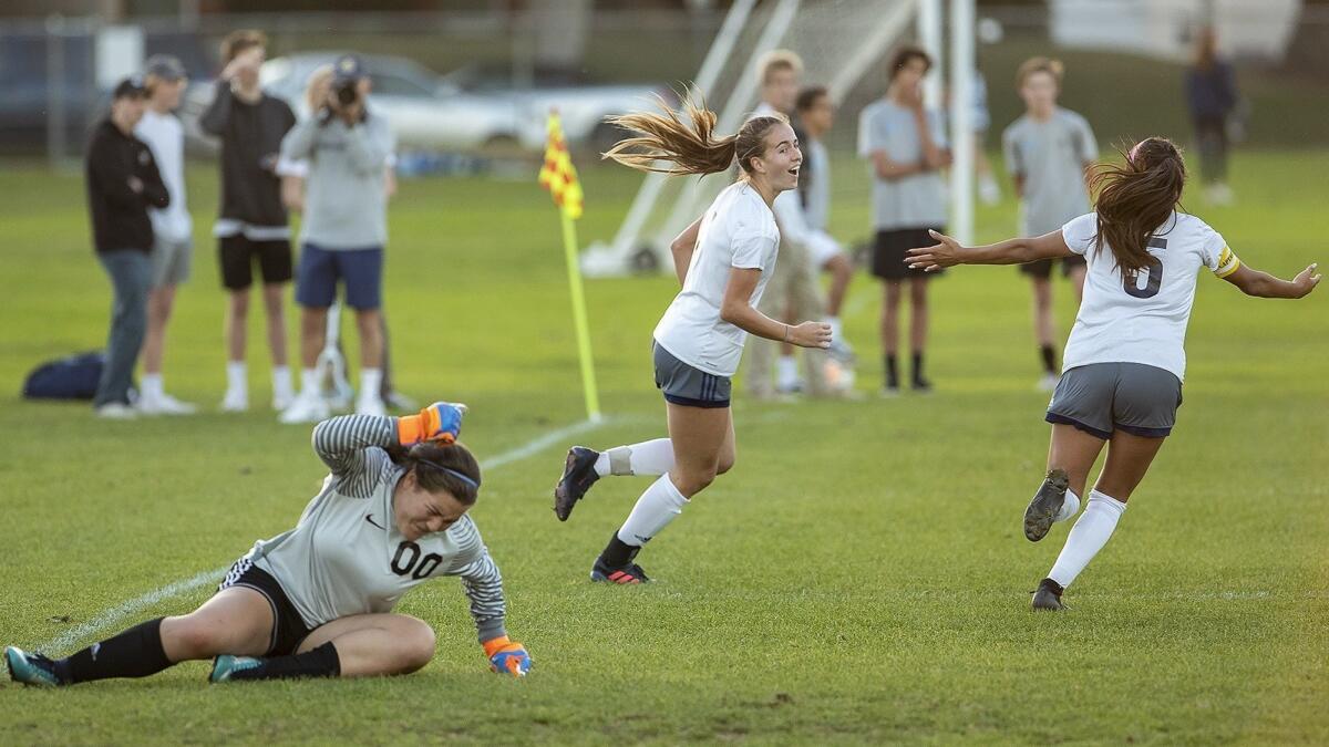Corona del Mar High goalkeeper Giovanna Broderick slams her fist to the ground as Newport Harbor's Sofia Velazquez, right, celebrates with Kenna Robar after Robar scored a goal on a header in the Battle of the Bay rivalry match on Thursday.