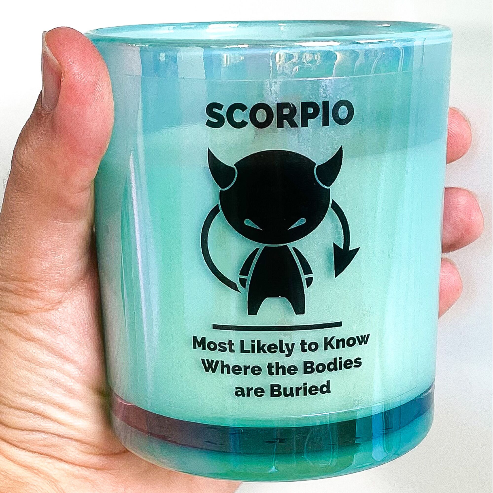 A "Scorpio" candle in a person's hand.