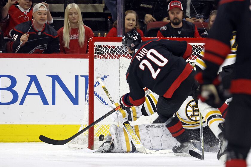 Carolina Hurricanes' Sebastian Aho (20) shoots the puck past Boston Bruins goaltender Linus Ullmark (partially obscured) for a goal during the first period of an NHL hockey game in Raleigh, N.C., Sunday, Jan. 29, 2023. (AP Photo/Karl B DeBlaker)