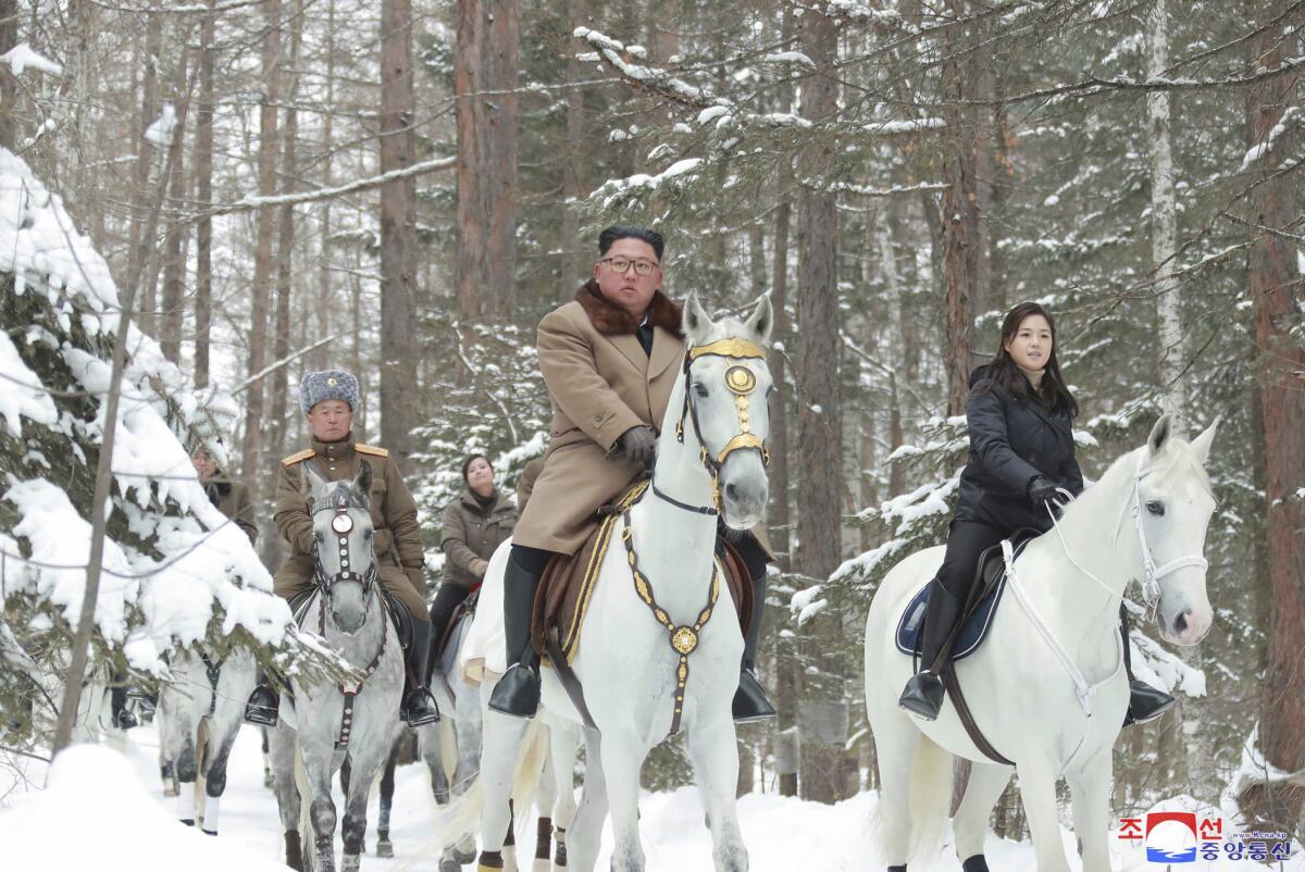 North Korean leader Kim Jong Un rides to Mt. Paektu with his wife, Ri Sol Ju, right, and other top lieutenants.
