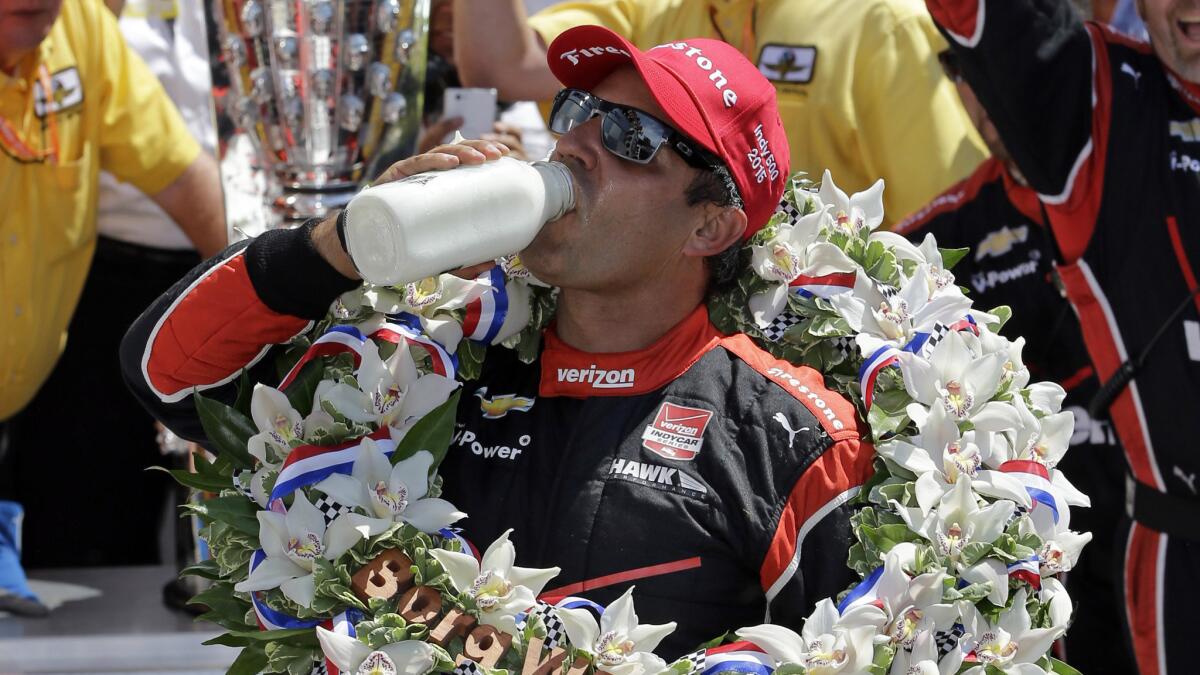 Juan Pablo Montoya celebrates by taking the traditional drink of milk after winning the Indianapolis 500 at the Indianapolis Motor Speedway on May 24, 2015.