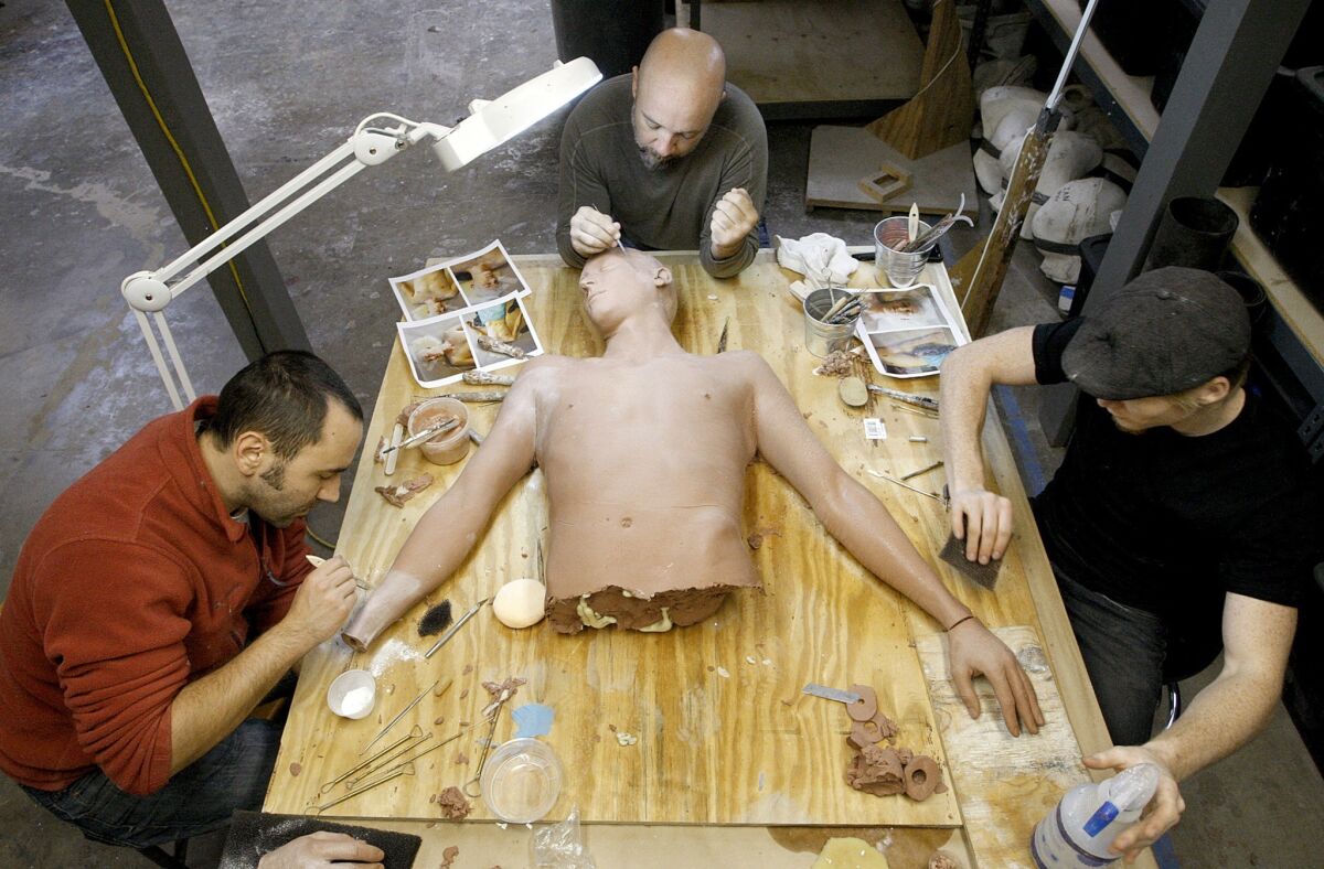 Daniel Tirinnanzi, left, Barney Burman and Ian Von Cromer work on a clay sculpture at B2FX in North Hollywood. The sculpture is for a character on the NBC television series "Grimm" who will get cut at the waist.