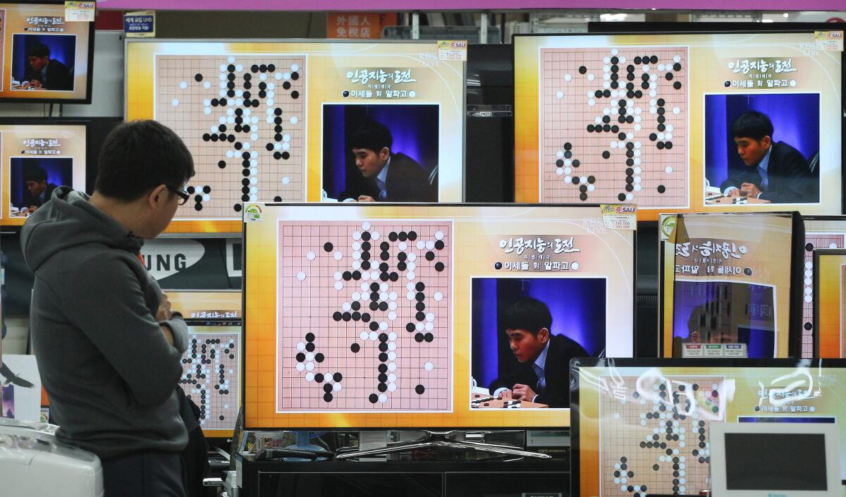 South Korean professional Go player Lee Sedol is shown on TV screens at an electronics store in Seoul during a match against Google's artificial intelligence program AlphaGo.
