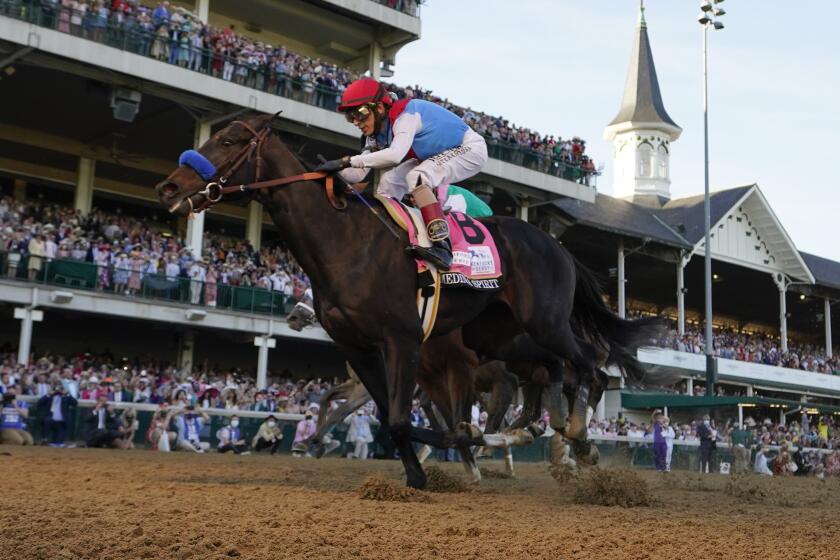 FILE - John Velazquez rides Medina Spirit across the finish line to win the 147th running.