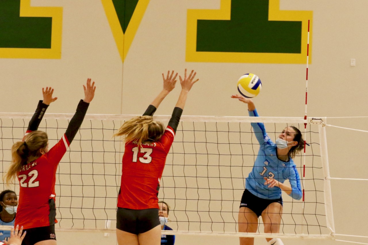 Marymount's Elia Rubin (right) spikes the ball against Mater Dei on Saturday.