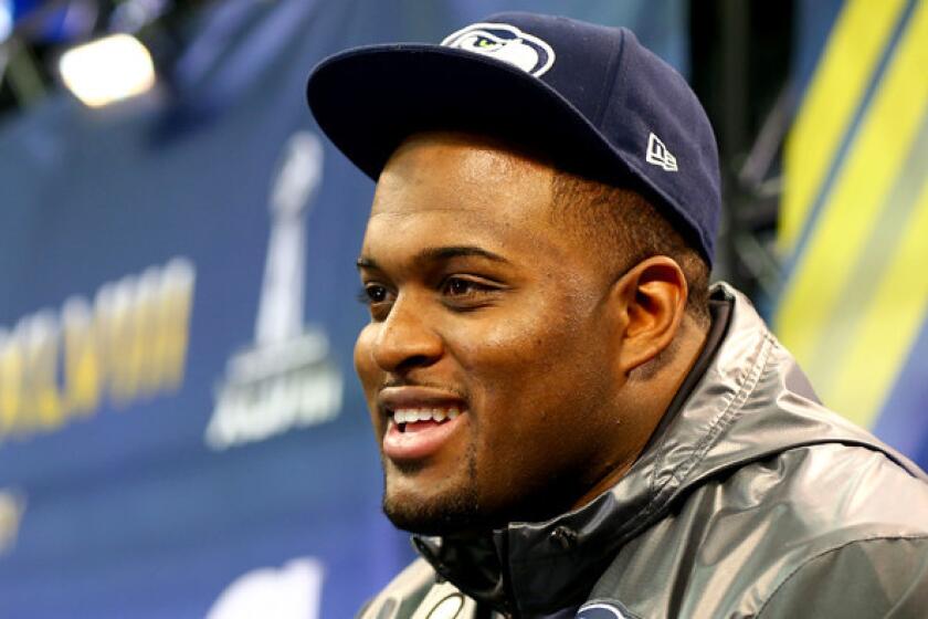 Defensive end Red Bryant talks to reporters during a media session at Super Bowl XLVIII.