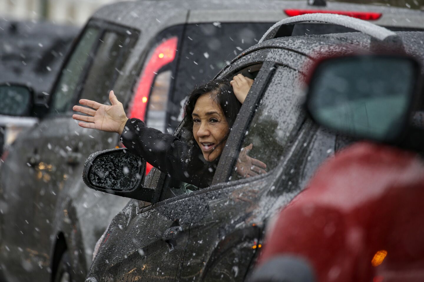 Liz Scales, 56, sticks her hand out to feel the falling snow in Rancho Cucamonga.