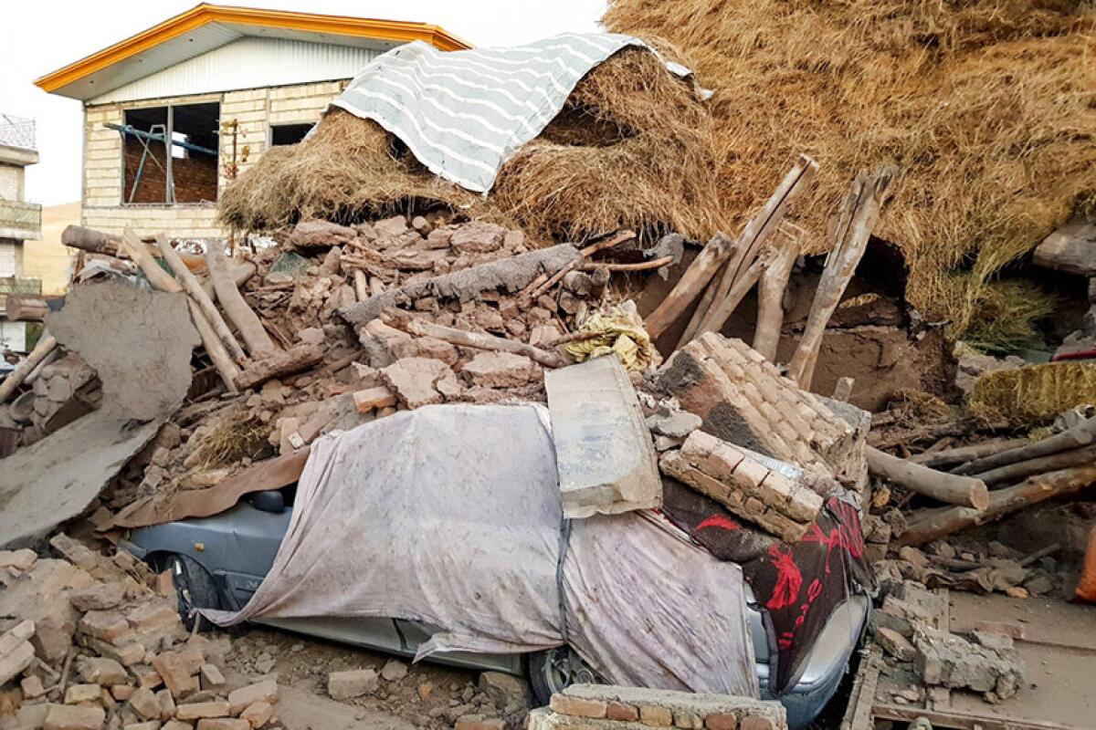 A car sits buried in debris from a building after Friday's earthquake in Iran's Eastern Azerbaijan province.