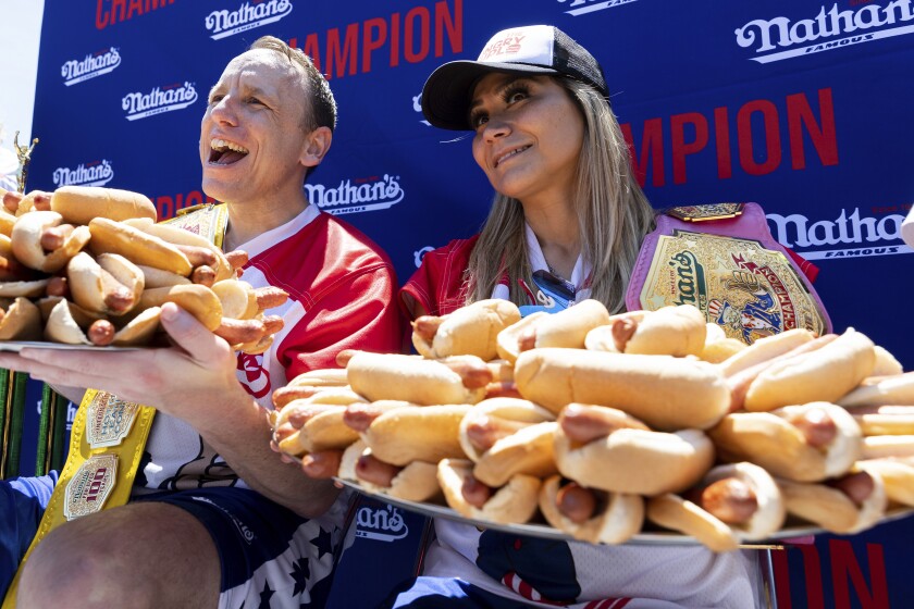Joey Chestnut and Miki Sudo pose with 63 and 40 hot dogs, respectively, after winning the Nathan's Famous Fourth of July hot dog eating contest in Coney Island on Monday, July 4, 2022, in New York. (AP Photo/Julia Nikhinson)
