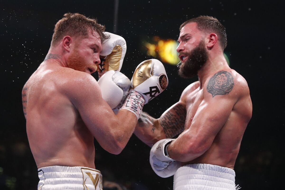 Canelo Álvarez, left, and Caleb Plant exchange punches during their fight Saturday.