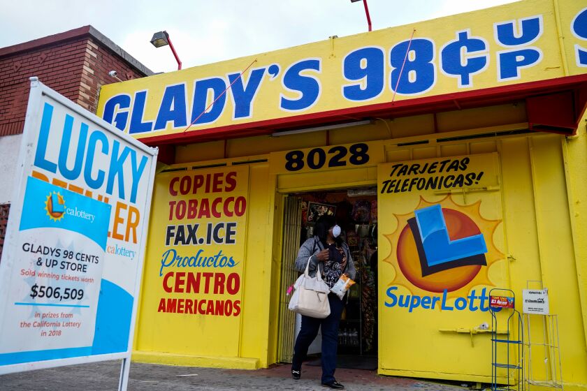 LOS ANGELES, CA - MARCH 14: A woman wearing a mask leaves GladyOs 98 in South LA on Saturday, March 14, 2020 in Los Angeles, CA. With the panic buying happening as a result of the widespread Coronavirus, people are looking to smaller shops like GladyOs 98 in South L.A. for supplies. (Kent Nishimura / Los Angeles Times)