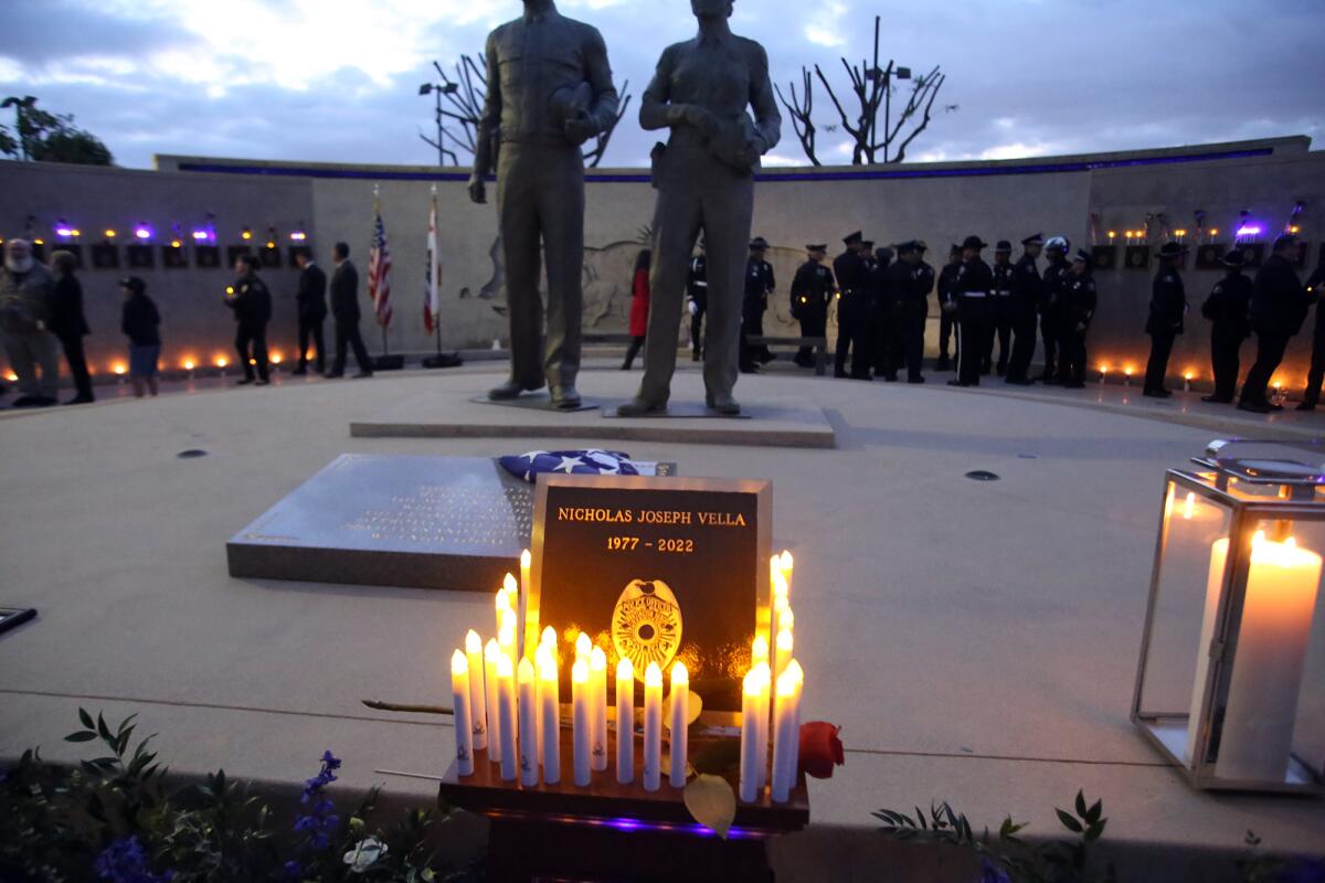 Candles surround the plaque of fallen Huntington Beach Police Officer Nicholas Joseph Vella during Thursday's ceremony.