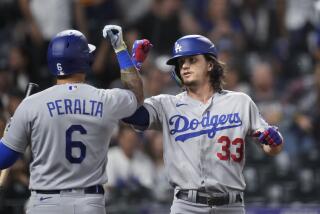 Los Angeles Dodgers' David Peralta, left, congratulates James Outman for a solo home run off Colorado Rockies starting pitcher Noah Davis during the third inning of a baseball game Wednesday, Sept. 27, 2023, in Denver. (AP Photo/David Zalubowski)