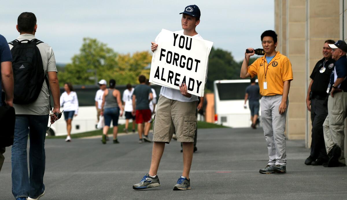 Andrew Limauro holds a sign outside Beaver Stadium protesting the school's decision to honor former head coach Joe Paterno on Saturday.