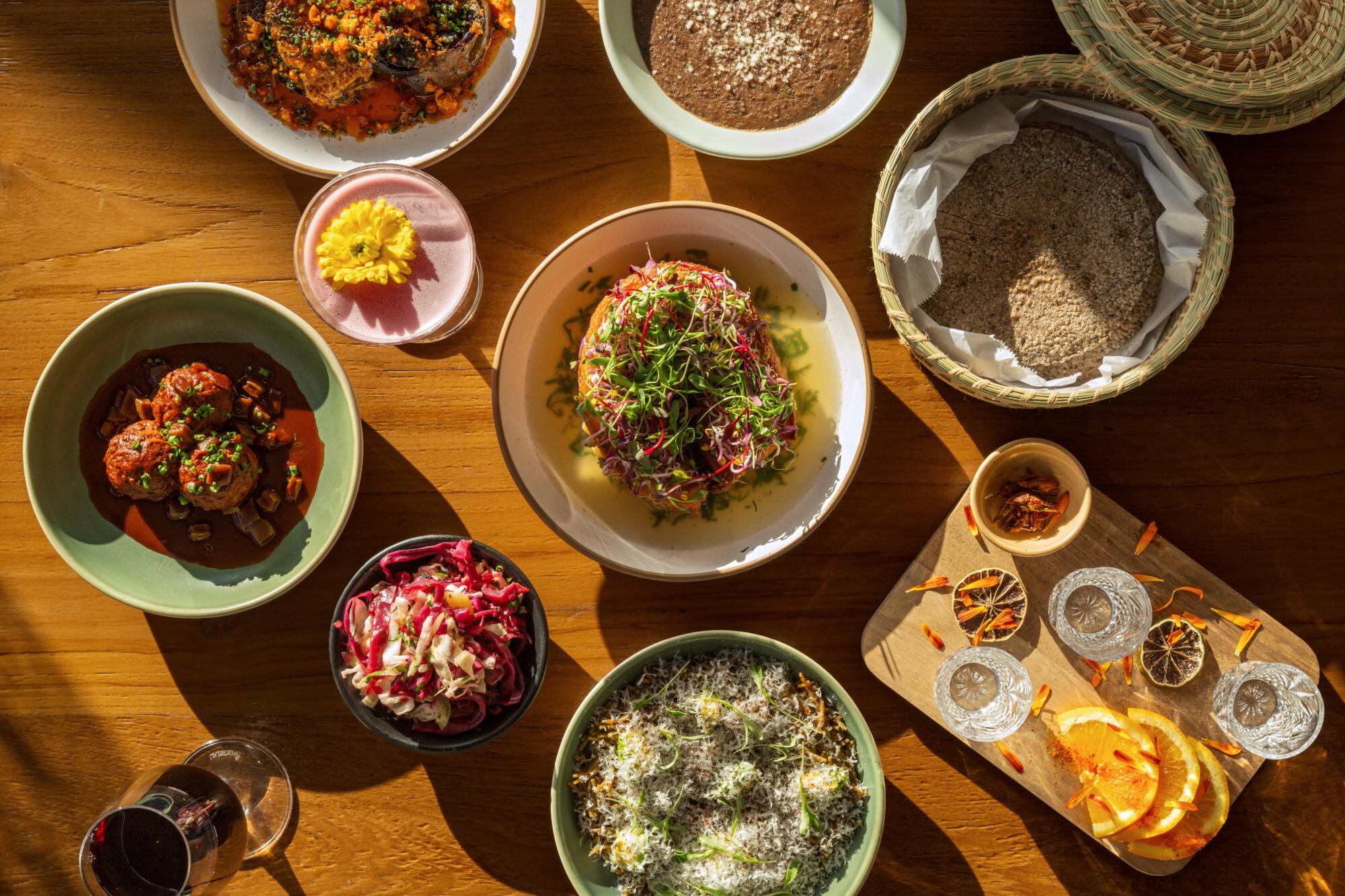 Batata doce, lentilha gelada, chicharrons, fideo verde e albondigas em comedor espanhol quebrado com coquetéis.
