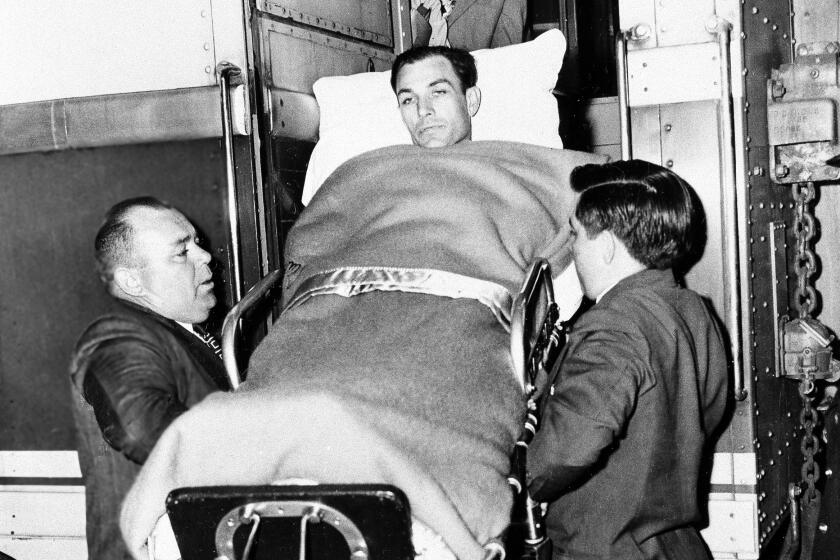 Golfer Ben Hogan of Fort Worth is ushered from train in which he made his trip back to Fort Worth.