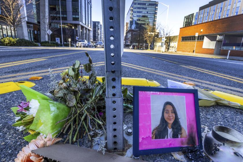 FILE - A photo of Jaahnavi Kandula is displayed with flowers, Jan. 29, 2023 in Seattle. A Seattle police officer and union leader under investigation for laughing and making callous remarks about the death of Kandula, from India, who was struck by a police SUV, has been taken off patrol duty, police said Thursday, Sept. 28. (Ken Lambert/The Seattle Times via AP, File)