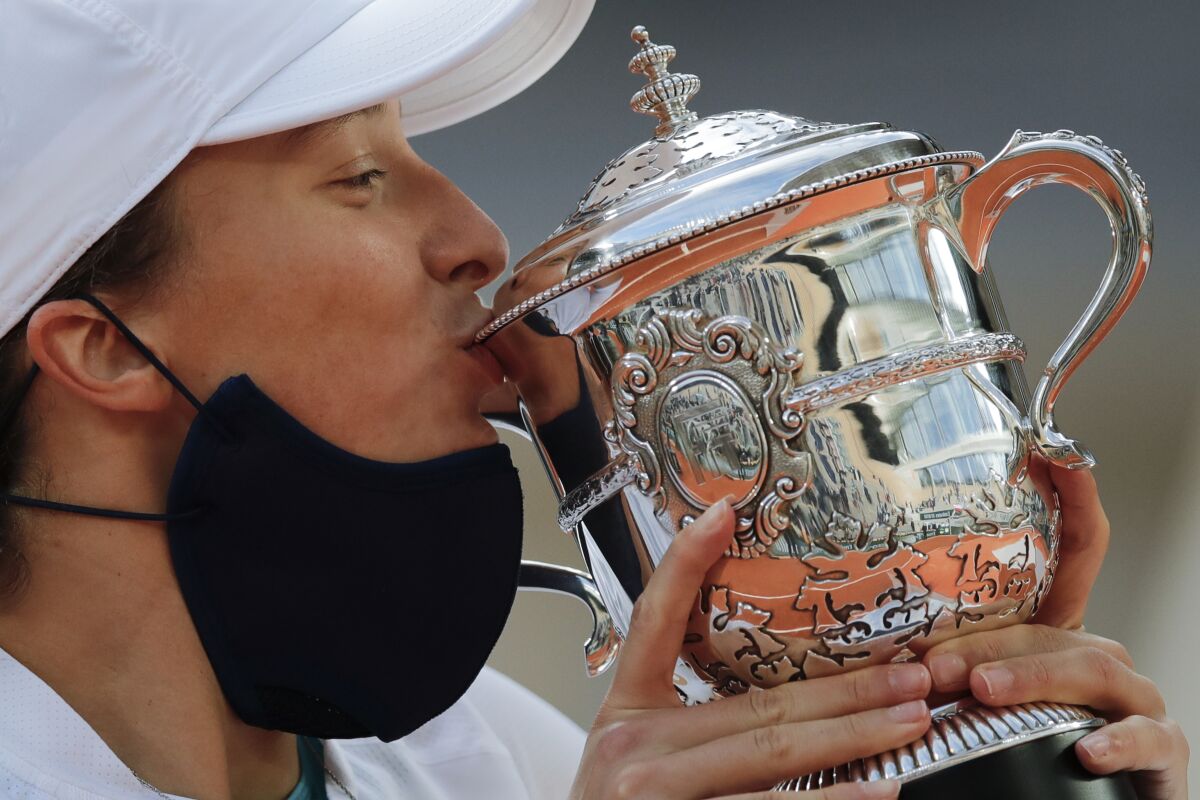 Poland's Iga Swiatek kisses the trophy after winning the final match of the French Open tennis tournament against Sofia Kenin of the U.S. in two sets 6-4, 6-1, at the Roland Garros stadium in Paris, France, Saturday, Oct. 10, 2020. (AP Photo/Christophe Ena)