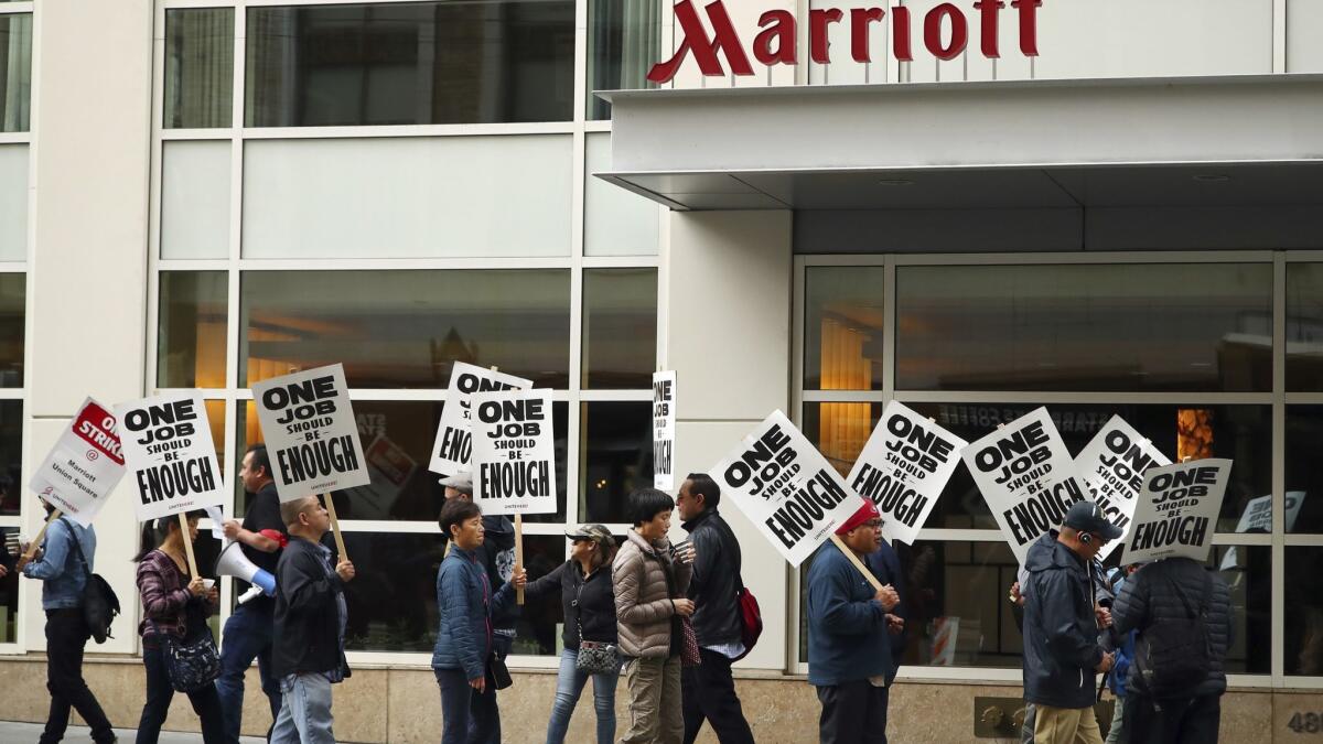 Hotel workers picket in front of a Marriott hotel in San Francisco on Oct. 4. Higher salaries and technology that could make some hotel jobs obsolete are among the issues under negotiation.