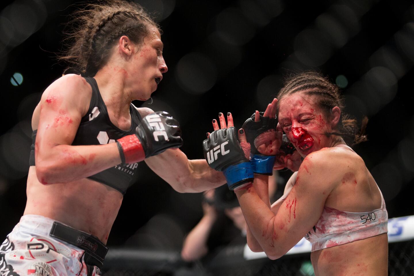 Joanna Jedrzejczyk, left, battles with Jessica Pennei for the women's strawweight title fight during UFC Fight Night in Berlin, Germany, Saturday, June 20, 2015. Jedrzejczyk defeated Pennei through KO/TKO.(AP Photo/Axel Schmidt)
