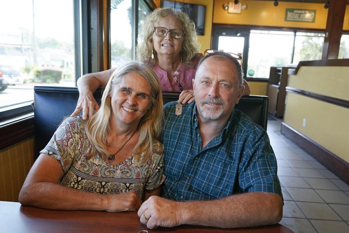 Two days after Debby-Neal Strickland, front left, and Jim Strickland were married in November, Debby donated a kidney to James' ex-wife Mylaen Merthe, center back, as the three get together Tuesday, May 25, 2021, at a restaurant in Ocala, Fla. (AP Photo/John Raoux)