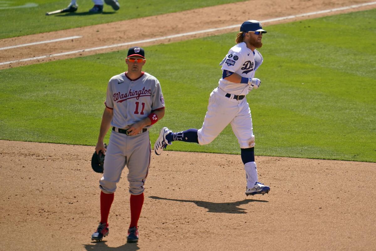 The Dodgers' Justin Turner rounds the bases past Nationals first baseman Ryan Zimmerman after homering April 9, 2021.