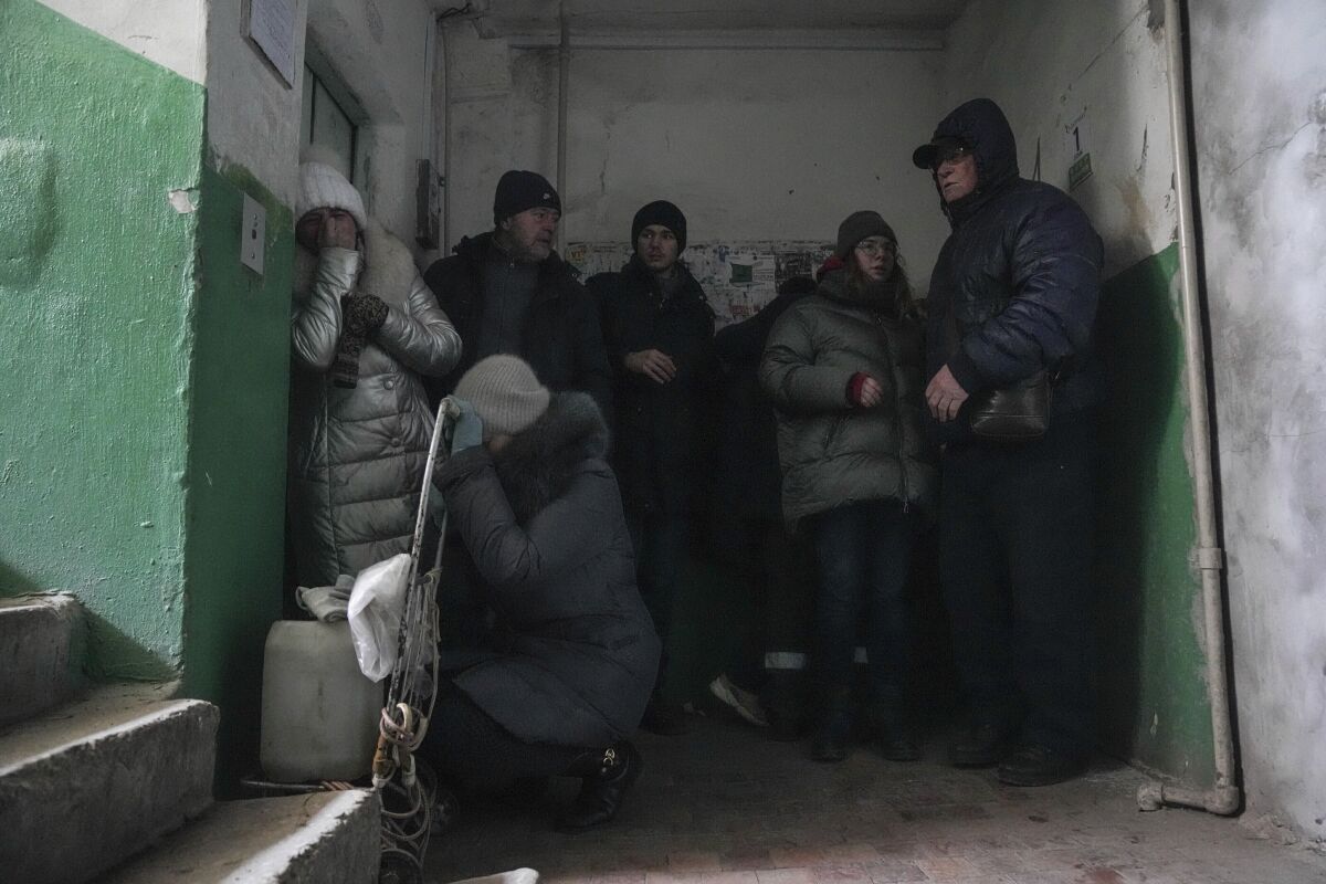 People cover from shelling inside an entryway to an apartment building in Mariupol, Ukraine, Sunday, March 13, 2022. (AP Photo/Evgeniy Maloletka)