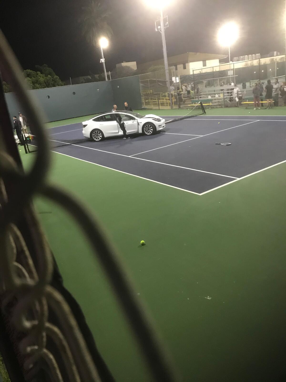 A car sits on a La Jolla Tennis Club court after crashing through the fence the evening of March 2.