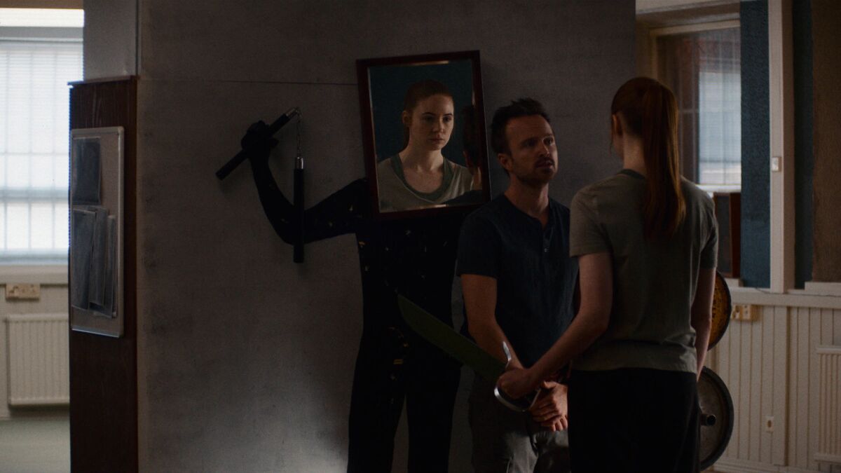 Aaron Paul and Karen Gillan face each other in a scene from 'Dual'