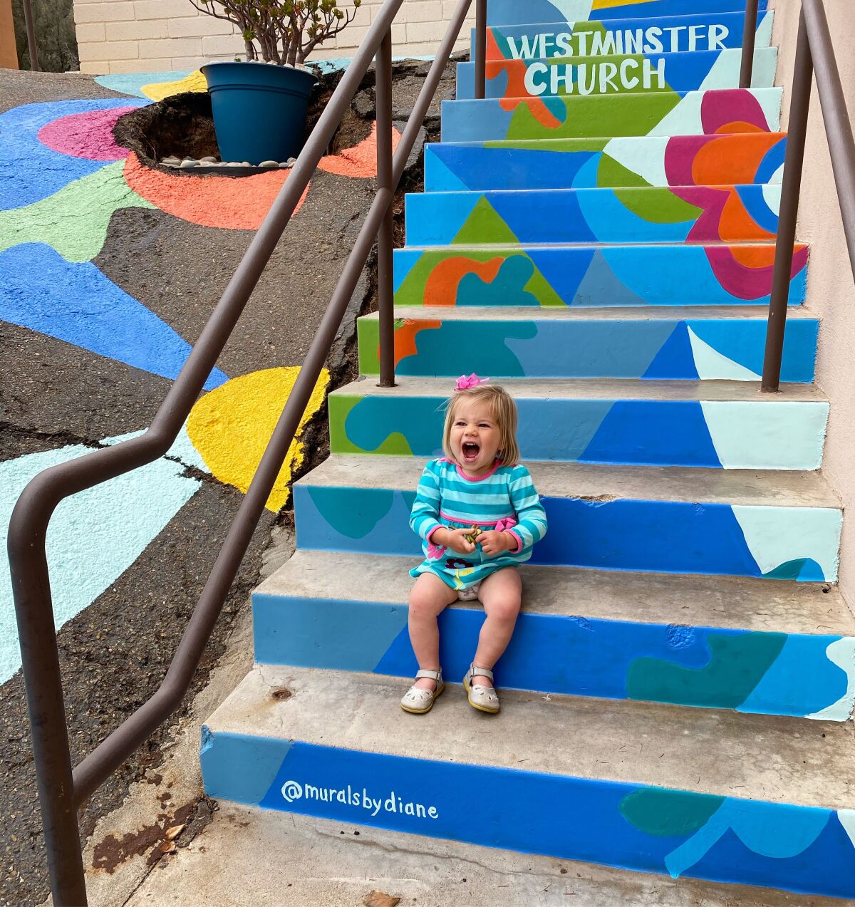 Diane Lehman's daughter, Rosie, sits on the steps that Lehman painted at Westminster Presbyterian Church in Point Loma.