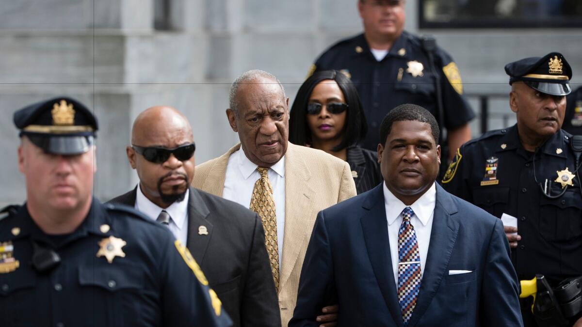 Bill Cosby, center, leaves a pretrial hearing at the Montgomery County Courthouse in Norristown, Pa., on Thursday.