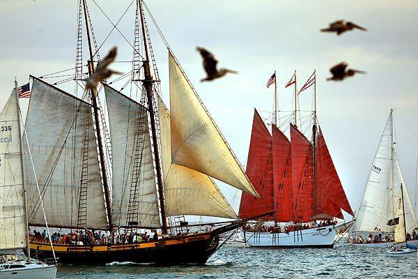 The Spirit of Dana Point (foreground) and the American Pride (center, with red sails) sail near the entrance to Dana Point Harbor as part of the 25th anniversary of the Tall Ships Festival held this weekend.