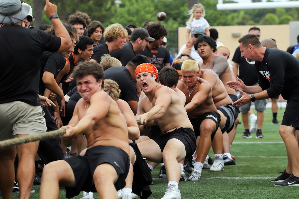 The Huntington Beach football team uses all its strength to compete in the tug-of-war competition on Saturday.